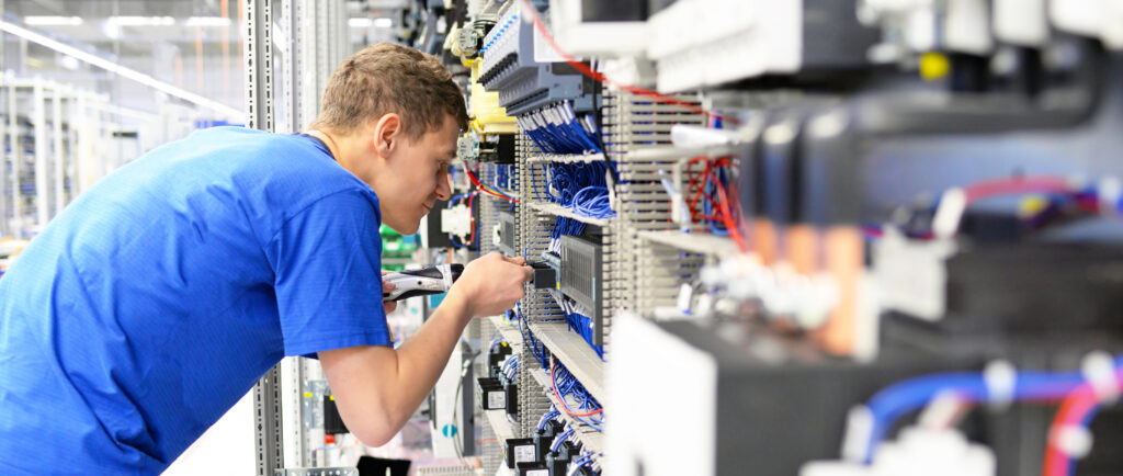 elektroniker montiert anlage in einer maschinenbaufabrik